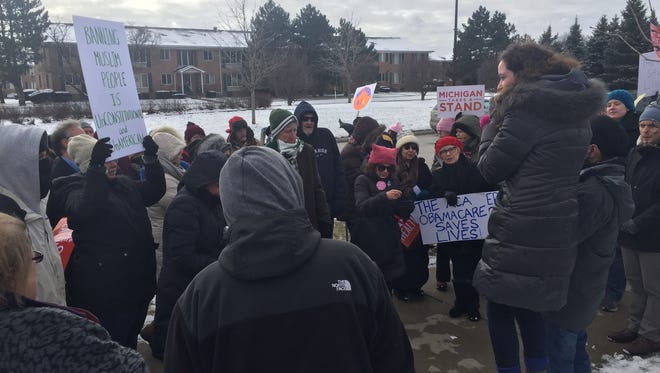 Nearly 200 people gathered in front of the Troy office of U.S. Rep. David Trott, R-Troy, to protest the health care and immigration policies of President Donald Trump.