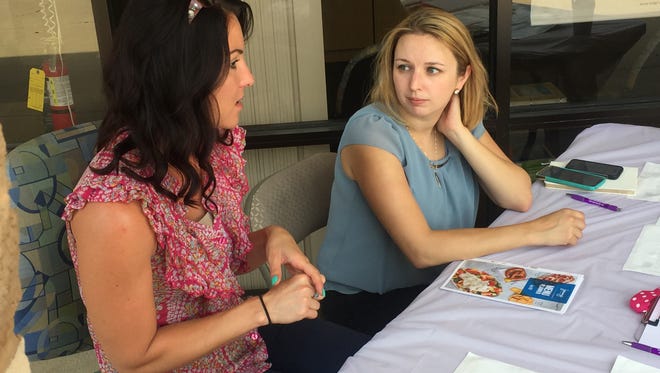 Jamilyn Ruckman and Sara Passaro, of the National Youth Advocate Program, discuss foster care services May 12, 2017, at an event in Pensacola. NYAP provides training and support to families who want to provide temporary foster care to children who've been victims of abuse or neglect.