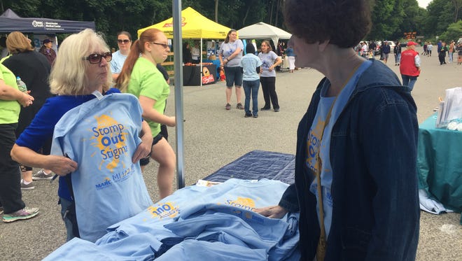 Kathleen Valentino, right, community events coordinator for Mental Health America of Dutchess County, assists Barbara Stonitsch of New Paltz as she purchases a shirt at the Stomp Out Stigma Awareness Walk held Saturday at Walkway Over the Hudson.