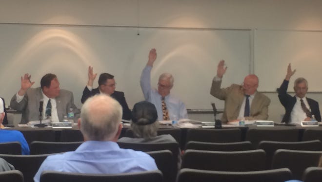 All five Madison County Commissioners raise their right hands to vote in favor of the county's 2017-18 budget.