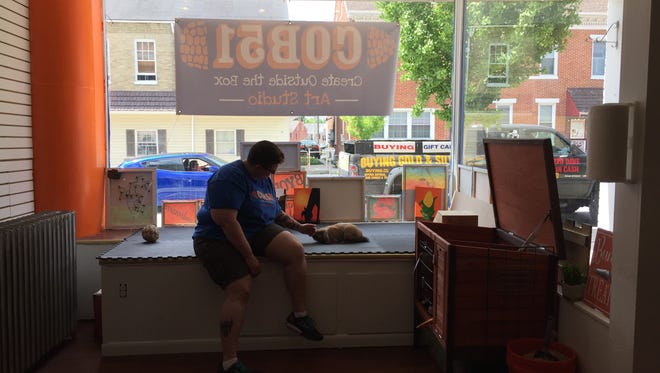 Lisa Martin, owner of COB51, sits with her pet rabbit, Bisquee, in the store front of her new art studio location on 34 York Street in Hanover. Bisquee, named after the oven fired ceramic material called bisque, if often outside of her box, hopping around in the store front window.