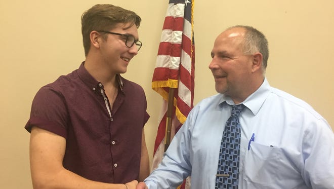 Emilio Horvath, Hartland High School junior, and Superintendent Chuck Hughes shake hands following the Sept. 18 Board of Education meeting.