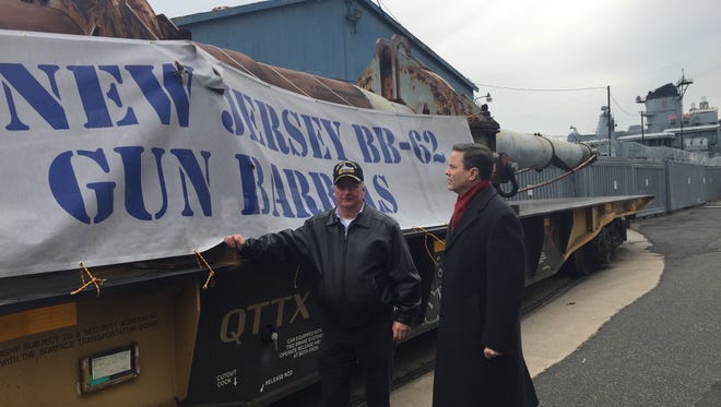 Two World War II battleship gun barrels are welcomed to the Battleship Museum and Memorial in Camden by museum CEO Philip Rowan and Rep. Donald Norcross, D-N.J. They arrived via rail before dawn Monday morning. The battleship smokestack is in the background.