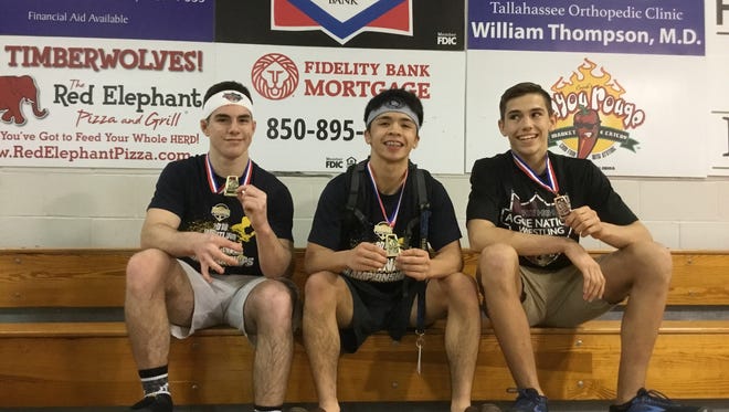 Tate High wrestlers Nathan Golmon, left, Jacob Cochran (center) and Mathew Blalock hold medals earned Saturday at the Region 1-2A Wrestling Championships in Tallahassee.