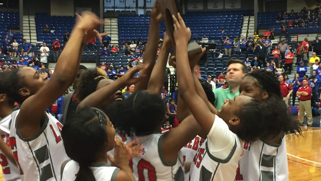 The North Caddo Lady Rebels hoist the LHSAA Class 2A state championship trophy Saturday in Rapides Coliseum.
