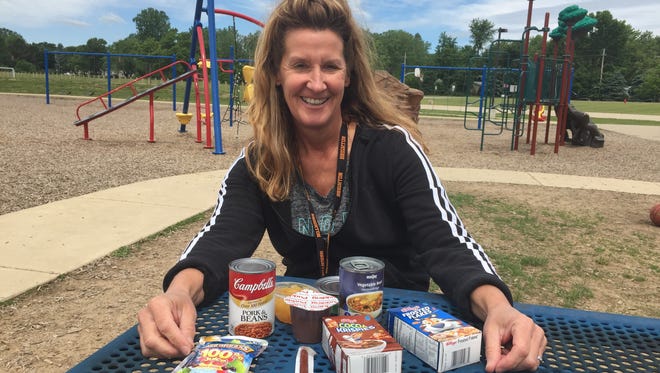 Lori Bolenga, Hawkins Elementary School lunch supervisor, with a sampling of the items sent home in Blessings in a Backpack, a program to ensure kids don't go hungry on the weekends.