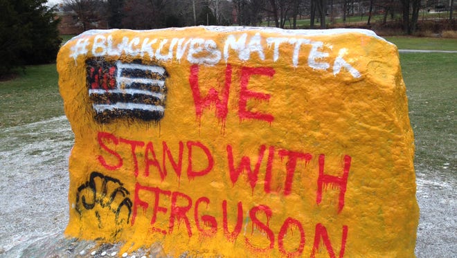 About 100 people gathered peacefully around the Michigan State University rock early this morning following the announcement that a Missouri officer will not face charges in connection to the fatal shooting of a black man, police said.