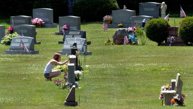 FILE - In this June 17, 2016 file photo, Erika Marble visits the gravesite of Edward Martin III, her fiancé and father of her two children, in Littleton, N.H. The 28-year old died Nov. 30, 2014, from an overdose of the opioid Fentanyl. Drug overdose deaths increased by 33 percent in the past five years across the U.S. as of 2016. New Hampshire saw a 191 percent increase while Massachusetts, North Dakota, Connecticut and Maine saw death rates jump by more than 100 percent.(AP Photo/Jim Cole, File)