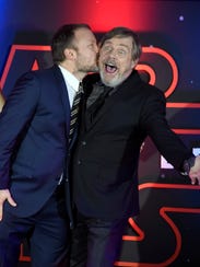 Rian Johnson kisses Mark Hamill during a red carpet