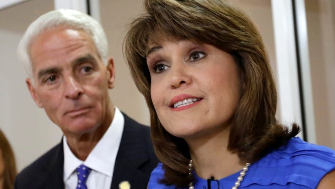 Annette Taddeo Goldstein, right, talks to reporters during a news conference as former Gov. Charlie Crist listens in Miami on July 17, 2014. Crist picked Taddeo, a former congressional candidate, as his running mate.  After years of running few Latinos for statewide posts, Democrats are building a bench that better reflects the support they have in the Hispanic community.