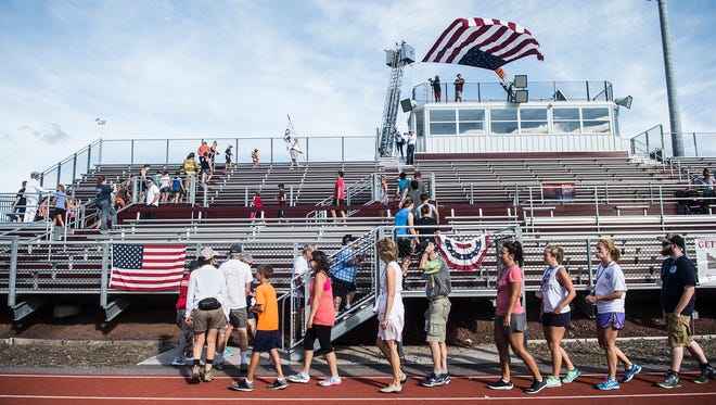 Participants walk the stairs of Warrior Stadium in tribute to the fallen firefighters of 9/11 in the Memorial Stair Climb organized by the Gettysburg Fire Department on Sunday.
