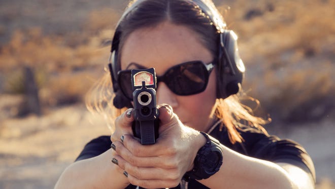 Sara Shertz, shown with a custom-built Glock 35, practices shooting in the desert near Sloan, Nev., on Oct. 19, 2014.