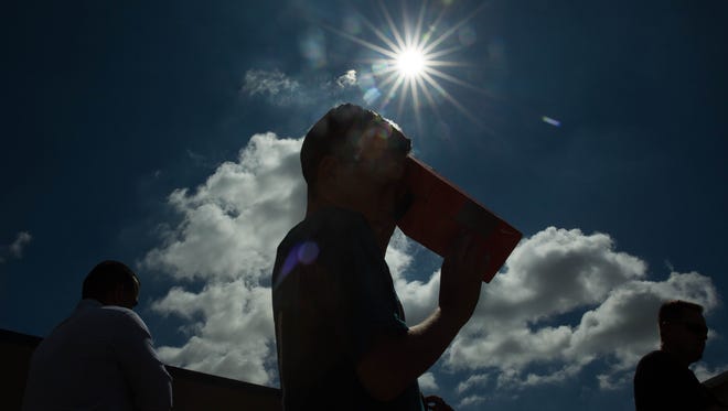 Aaron Muñoz, 11, a sixth-grader at Vista Middle School, uses a pin hole viewer to watch as the solar eclipse begins over Las Cruces on Monday Aug. 21, 2017.