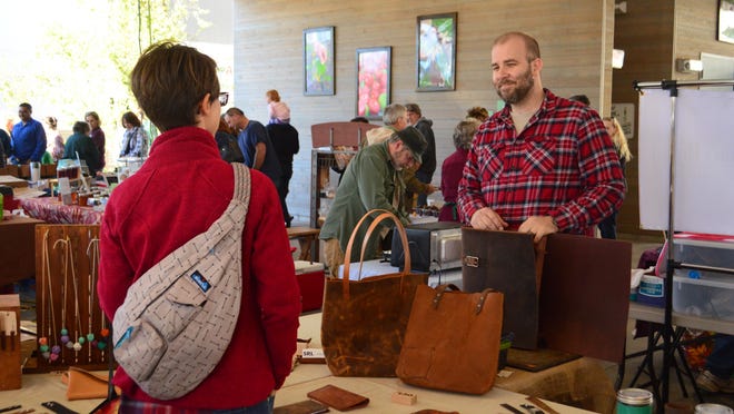 Jason Hooge, owner of Salt River Leather, talks to a potential customer at Farmers Market of the Ozarks.