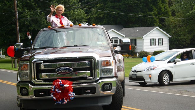 Charlotte Erbland waves during the Erbland family reunion parade in Webster on Aug. 15, 2015.