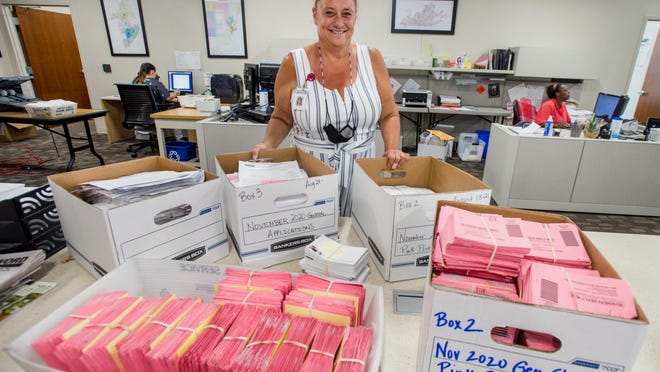 Election specialist Debbie Emanuels shows off some of the 25,000 requests for mail-in ballots that have been processed at the Peoria County Election Commission.
