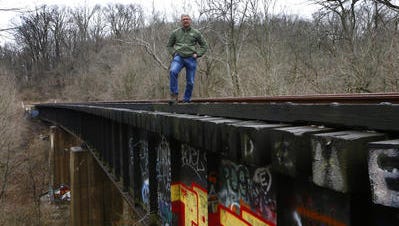 Jay Andress, of Hype Park, in 2013 stands on the train trestle in Ault Park near Old Red Bank Road. He's working on the effort to get the Wasson Way bike and pedestrian trail built.