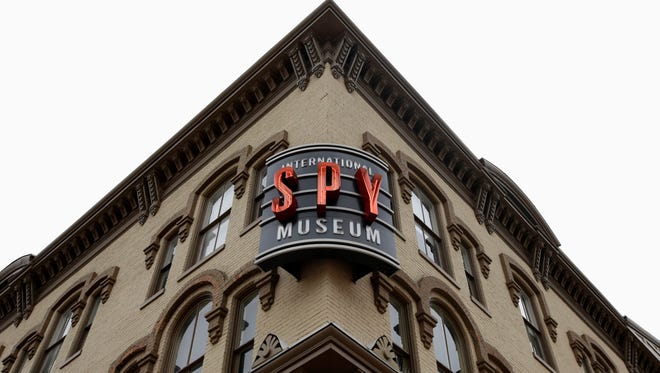 A sign for the International Spy Museum is lit up around the corner from the Adams Building which currently houses the museum, in Washington on Monday.