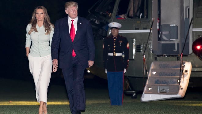 President Trump and first lady Melania Trump walk from Marine One across the South Lawn to the White House in Washington on May 27, 2017, as they return from Sigonella, Italy.