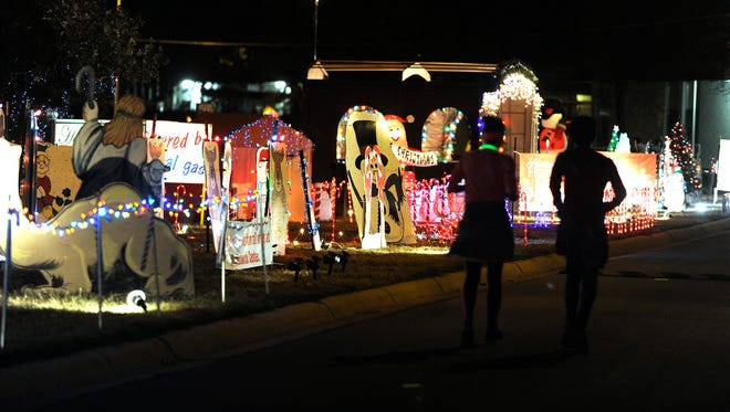 A pair of runners pass through the holiday displays during the Christmas Lane 5K on Thursday, Dec. 1, 2016, at the Abilene State Supported Living Center.