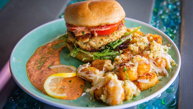 The popular lump crab meat burger with garlic-Parmesan tater tots at Catch Clean Cook Marketplace and Deli.