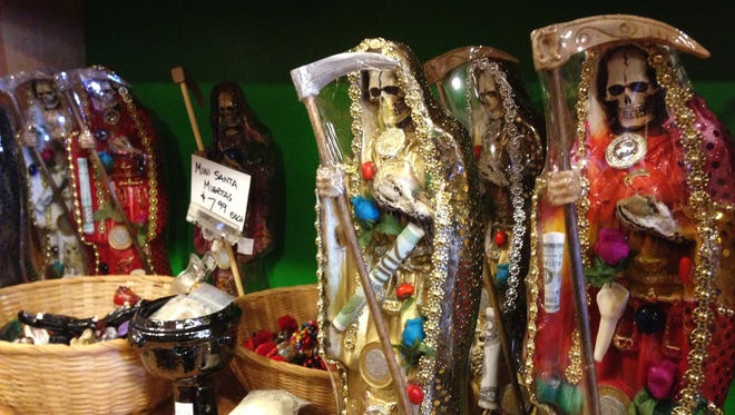 In this Feb. 13, 2013 photo, statues of La Santa Muerte are displayed at the Masks y Mas art store in Albuquerque, N.M. Bishops in the United States are finally denouncing the skeleton folk saint known as La Santa Muerte, a figure often connected to the illicit drug trade in Mexico.
