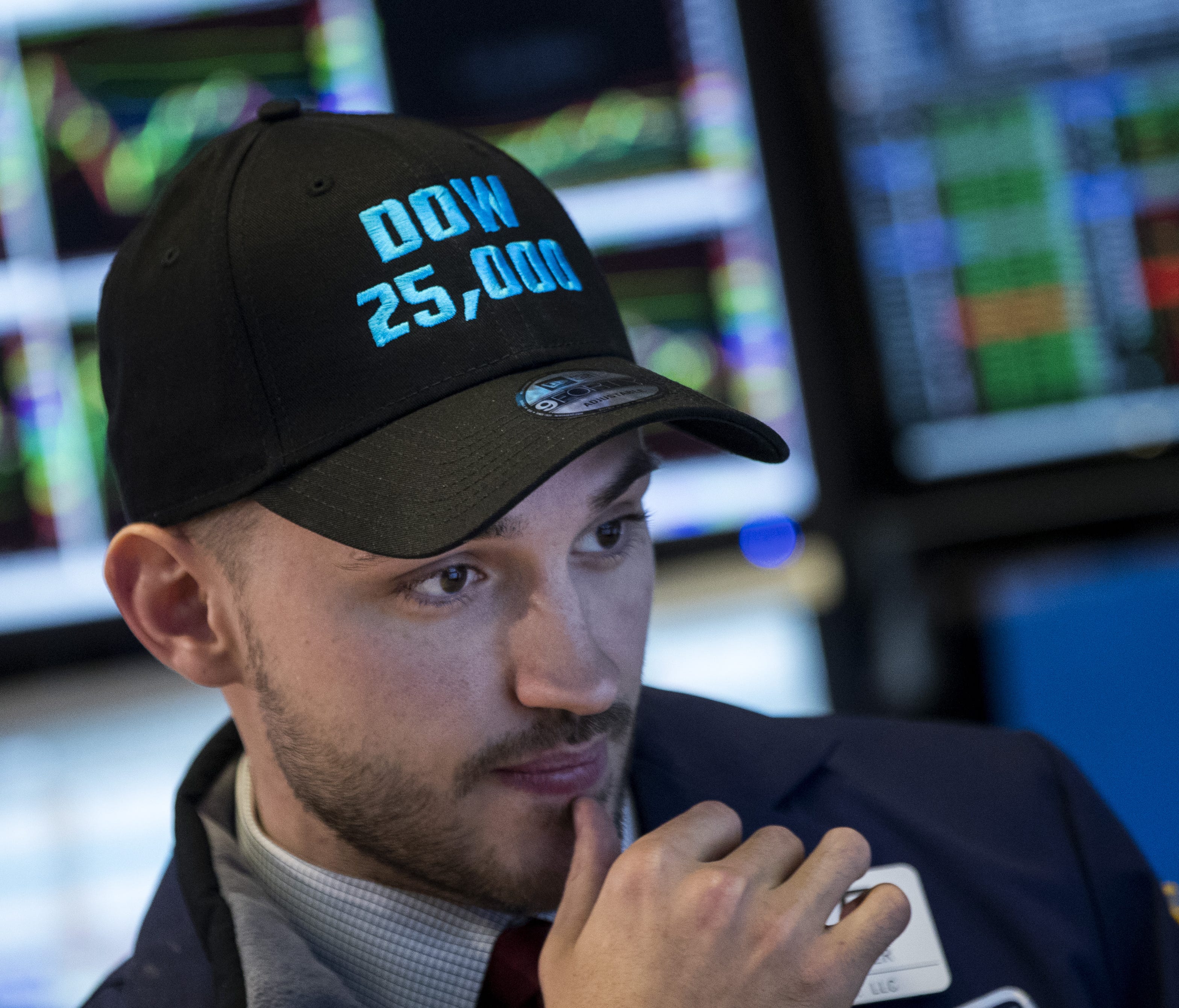 A trader wearing a 'Dow 25,000' hat works on the floor of the New York Stock Exchange (NYSE) ahead of the closing bell, January 4, 2018 in New York City. The Dow closed above 25,000 for the first time ever on Thursday.