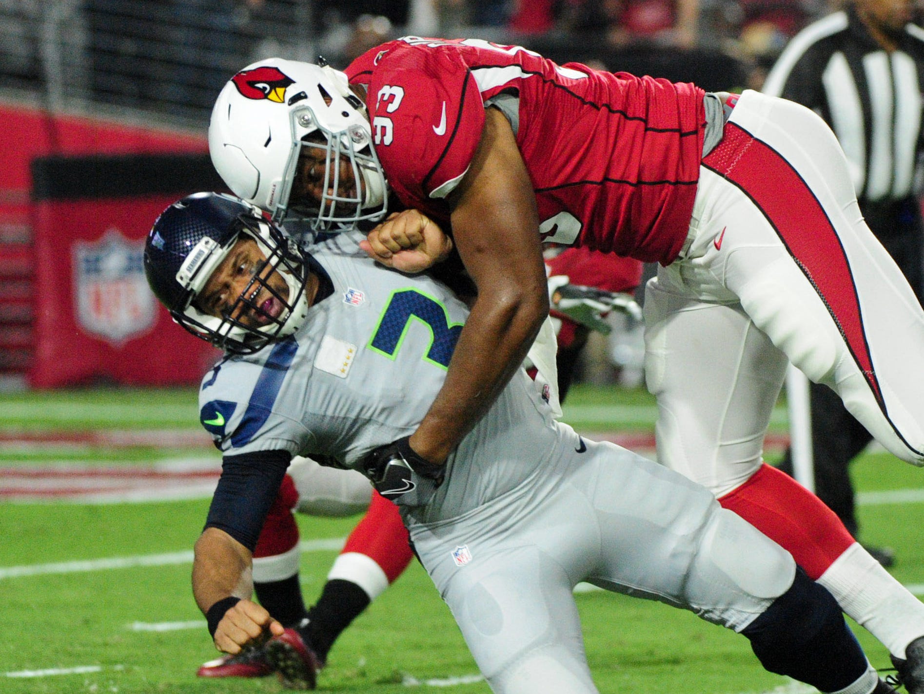Arizona Cardinals defensive end Calais Campbell (93) tackles Seattle Seahawks quarterback Russell Wilson (3) during the first half at University of Phoenix Stadium.