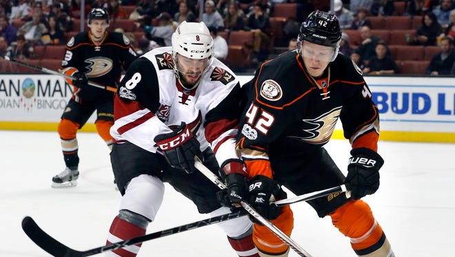 Arizona Coyotes' Tobias Rieder, left, and Anaheim Ducks' Josh Manson (42) battle for the puck in the first period of an NHL hockey game in Anaheim, Calif., Friday, Jan. 6, 2017.