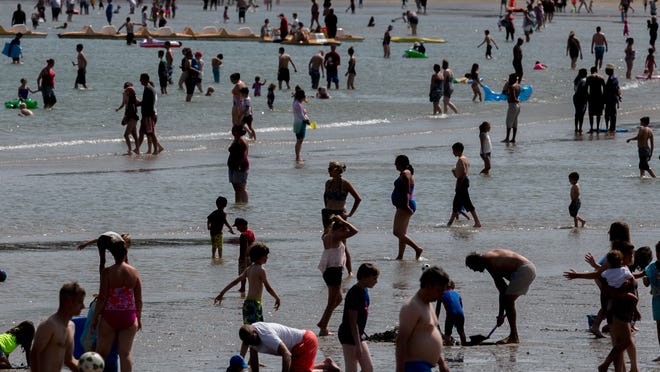 People paddle in the sea as they try to keep cool on the seafront on July 30 in Weymouth, England. The United Kingdom observed a July temperature that was the 8th warmest July in the 115-year period of record.