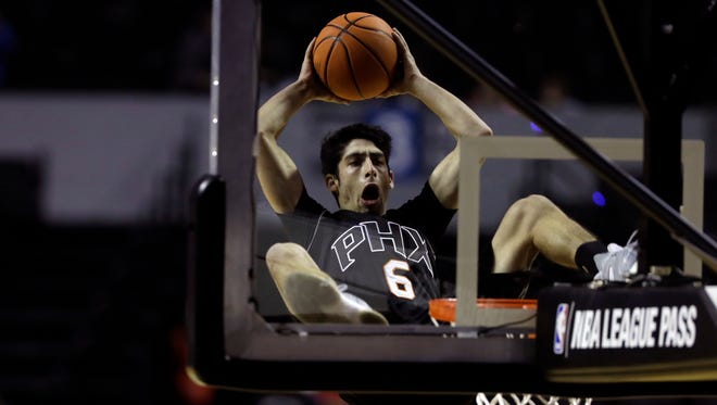 Dylan, associated with the Phoenix Suns, goes for the basket from a trampoline during a show before the start of a regular-season NBA basketball game between the Phoenix Suns and Dallas Mavericks in Mexico City, Thursday, Jan. 12, 2017. (AP Photo/Rebecca Blackwell)