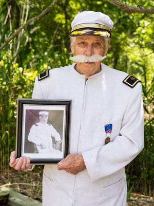 Thomas Creekmore holds a photo of Admiral Dewey on Friday, June 10 in Bewey Beach.