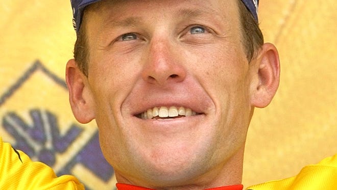 In this 2004 file photo, Lance Armstrong waves from the podium after winning the 15th stage of the Tour de France cycling race. Armstrong is facing the federal government in a legal fight with tens of millions of dollars at stake, and a loss could bankrupt the cyclist who until last year ranked among the wealthiest and most popular athletes in the world.