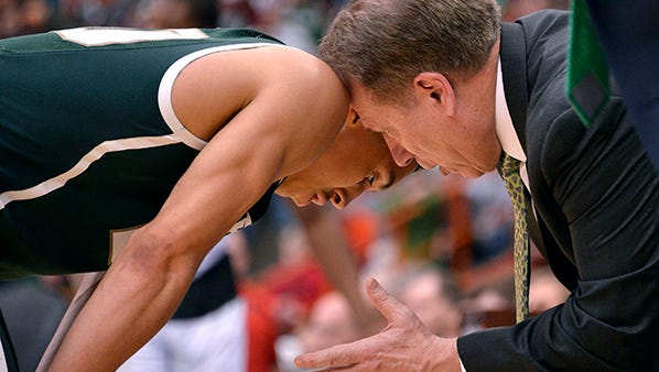 Tom Izzo has a close encounter with Travis Trice during Sunday's game against Louisville.