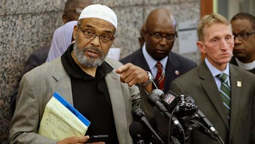 Abdullah Faaruuq, Imam of the Mosque for the Praising of Allah, left, speaks to reporters during a news conference as Darnell Williams, president of the Urban League of Eastern Massachusetts, behind center, Boston Police Commissioner William Evans, front right, and Rev. Arthur Gerald, Jr., president of the Black Ministerial Alliance of Greater Boston, right, look on during a news conference, Wednesday, June 3, 2015, at Boston Police Headquarters, in Boston. Boston police said they have video showing Usaama Rahim, a man who was under 24-hour surveillance by terrorism investigators, lunging with a knife at a police officer and an FBI agent before he was shot and killed. (AP Photo/Steven Senne)