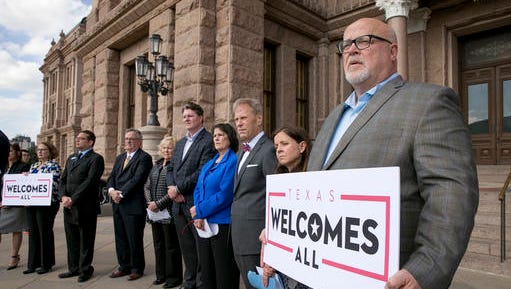 FILE - In this Jan. 11, 2017, file photo, Brad Kent, Chief Sales and Services Officer for Visit Dallas, holds a sign at a news conference at the Capitol in Austin, Texas, to oppose a Texas "bathroom bill." The NFL is expressing sharper warnings about a Texas "bathroom bill" targeting transgender persons than statements prior to the Super Bowl in Houston. NFL spokesman Brian McCarthy on Friday, Feb. 10, 2017,  raised the prospect of Texas losing out on future Super Bowls if there were laws "discriminatory or inconsistent with our values." He said such measures "would certainly be a factor" taken into consideration.