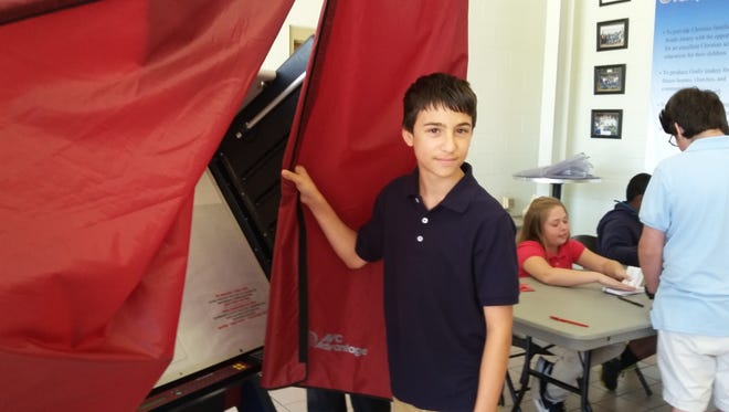 Paul Wroniuk Jr., a seventh grader at Cumberland Christian School in Vineland, gets ready to enter the voting booth for the school’s mock election.