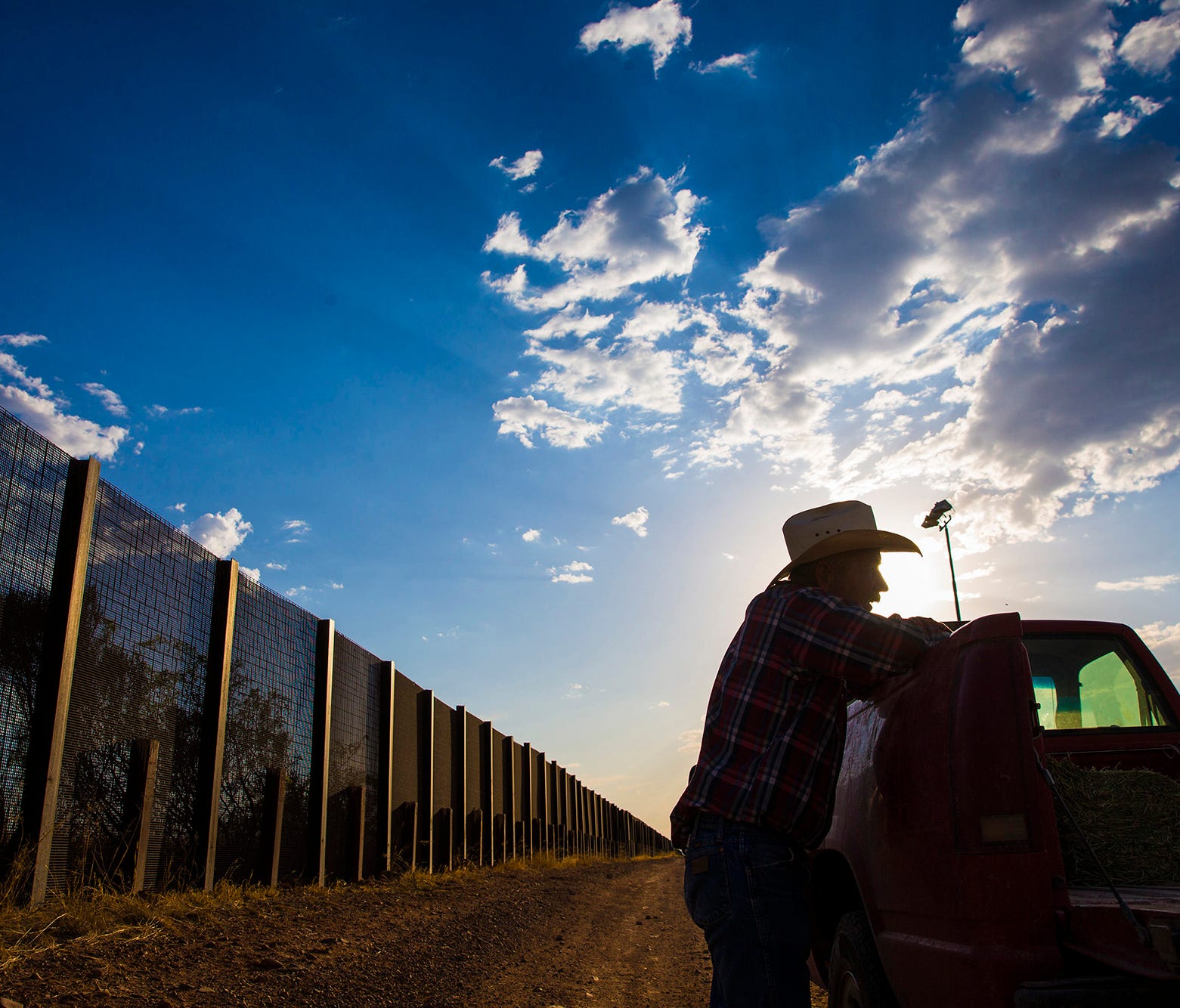 May 5, 2017; Naco, Ariz, USA; Rancher John Ladd leans on his truck on his ranch, which borders with Mexico (behind him). He has been frustrated for years over the illegal border crossers and drug smugglers that cut through his ranch. The 16,000 acre 