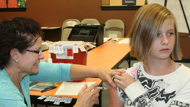 Carly Totman receives a flu shot at Fernley High School in 2012. Community health nurse offices have conducted clinics and made visits for the homebound.