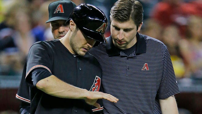Arizona Diamondbacks center fielder A.J. Pollock has his hand checked out after being hit by a pitch on Saturday, May 31, 2014, in Phoenix.