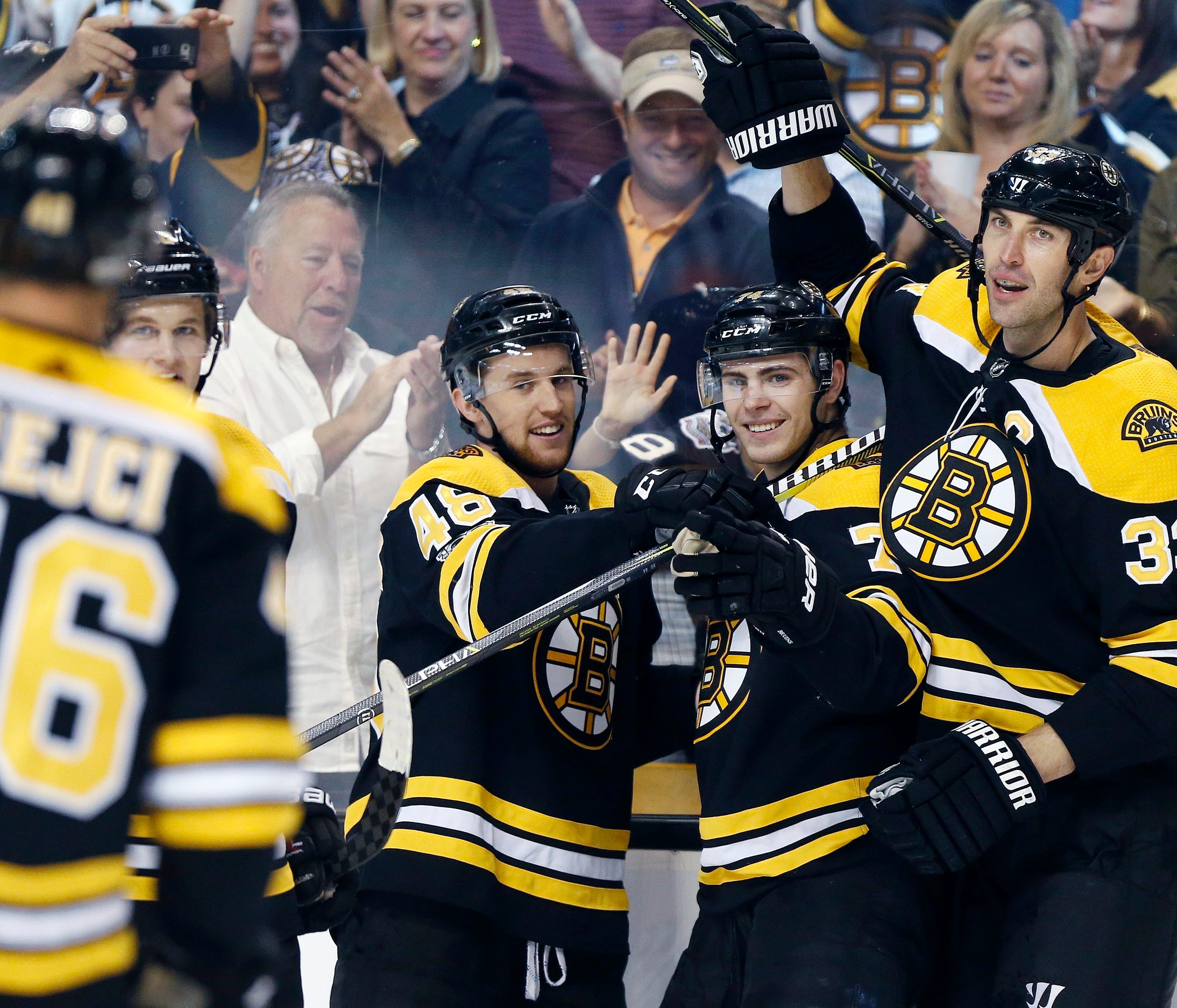 Boston Bruins' Jake DeBrusk (74) celebrates his goal with Matt Grzelcyk (48) and Zdeno Chara (33) during the second period of an NHL hockey game in Boston, Thursday, Oct. 5, 2017. (AP Photo/Michael Dwyer) ORG XMIT: MAMD101