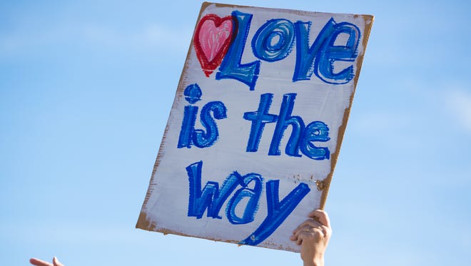 Laurie Shade-Neff, of Las Cruces, hold a sign that read, "Love is the way," on Sunday January 14, 2018 for the annual MLK March sponsored by the Doña Ana County Branch of the NAACP.