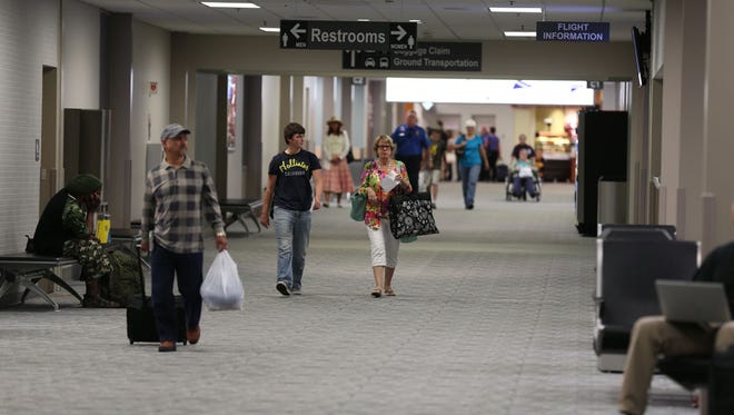 Passengers walk through the terminal at the Des Moines International Airport on Tuesday, July 1, 2014, in Des Moines, Iowa.