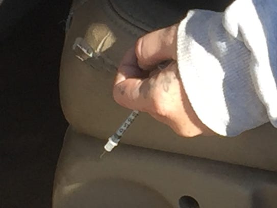 Erika P. Hurt's left hand holds a hypodermic needle