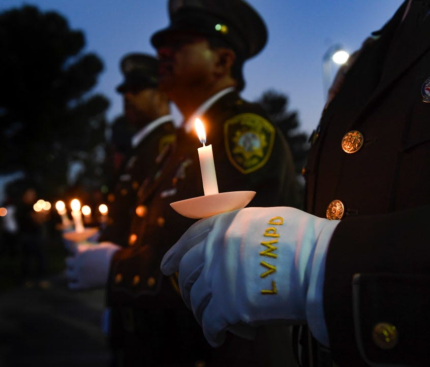 Officer Michael Lemley of the Las Vegas Metropolitan Police Department stands with fellow officers at a candlelight vigil for Charleston Hartfield at Police Memorial Park in Las Vegas Oct. 5, 2017.