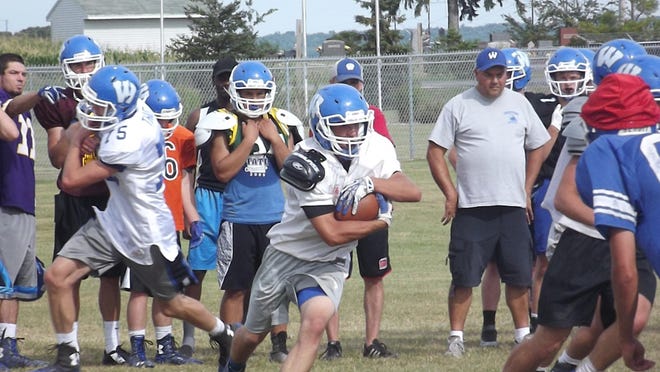 Wrightstown senior Hunter Kussow takes a handoff at an Aug. 6 practice. Kussow rushed for 811 yards and 10 touchdowns last season.
