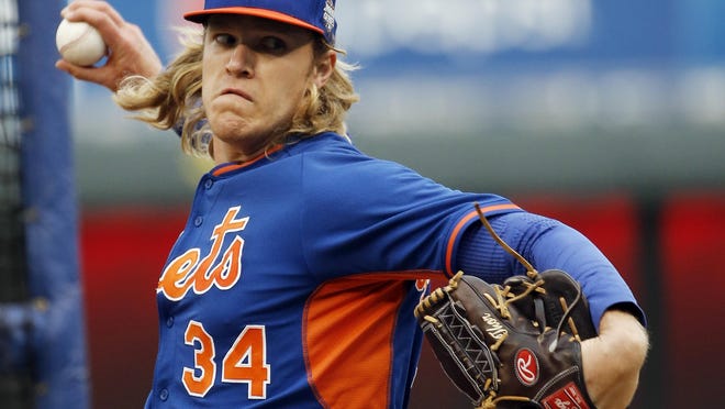New York Mets pitcher Noah Syndergaard has the name Thor monogrammed on his glove as he throws at batting practice for the Major League Baseball World Series against the Kansas City Royals Monday, Oct. 26, 2015, in Kansas City, Mo.