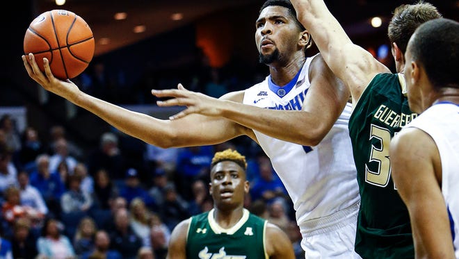 University of Memphis forward Dedric Lawson (left) puts up a shot against the University of South Florida defender Ruben Guerrero  (right) during second action. Lawson, finished with 11 points while adding five assist and five blocks.