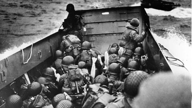 
In this June 6, 1944 file photo, allied troops crouch behind the bulwarks of a landing craft as it nears Omaha Beach in Normandy, France. 
