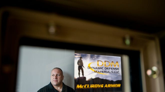 Jos Dimond, owner of Dynamic Defense Materials, is seen through the bullet-proof glass of one of his military guard posts. Douglas Bovitt/Courier-Post